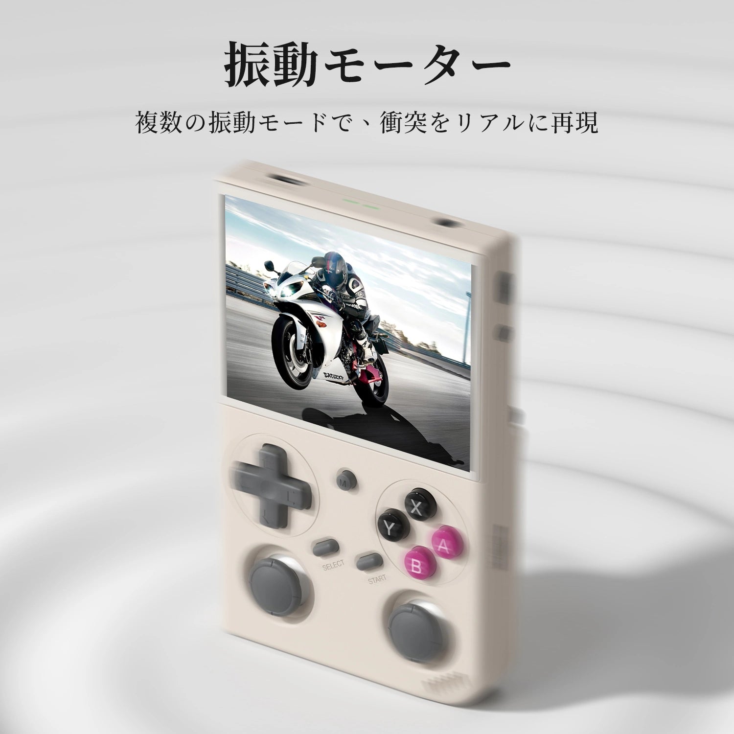 ベージュの携帯ゲーム機。画面に白いバイクが走るレースゲームが表示され、十字キーと2つのアナログスティック、カラーのABXYボタンがある。上部に振動モーター機能の説明。